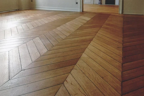 Intérieur résidentiel avec parquet en bois massif posé en motif chevron ou point de Hongrie