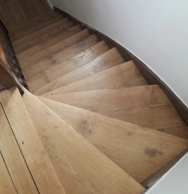 Escalier courbe en bois naturel avec marches en chêne massif et contremarches assorties