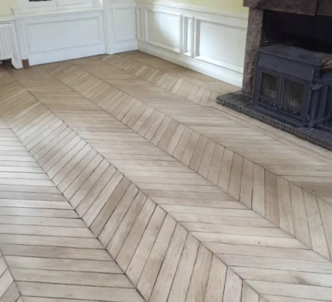 Intérieur résidentiel avec parquet en bois clair disposé en motif chevron complexe