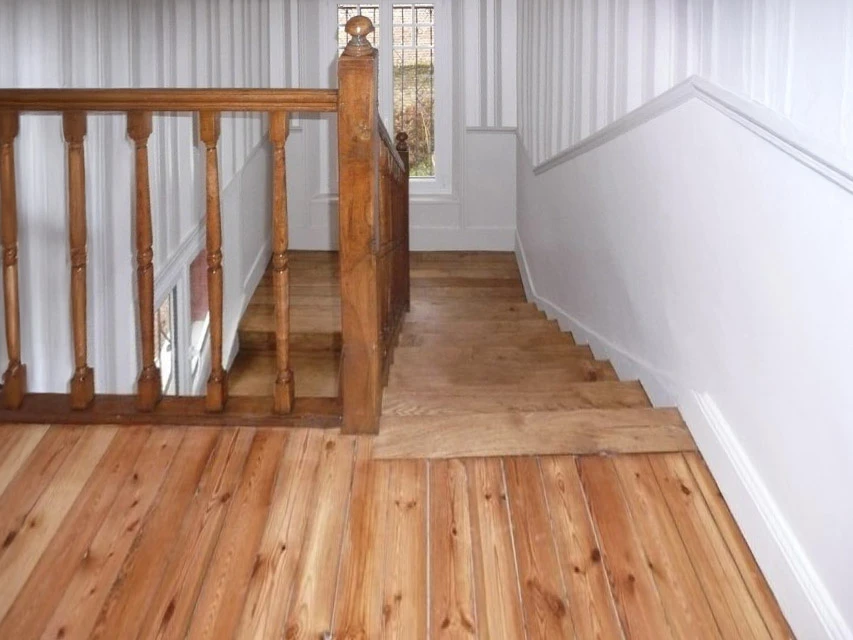 Intérieur résidentiel avec parquet en bois clair disposé en motif chevron complexe