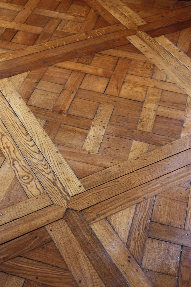 Intérieur moderne avec parquet en bois naturel clair, chaises en bois contemporaines et table avec piètement métallique noir