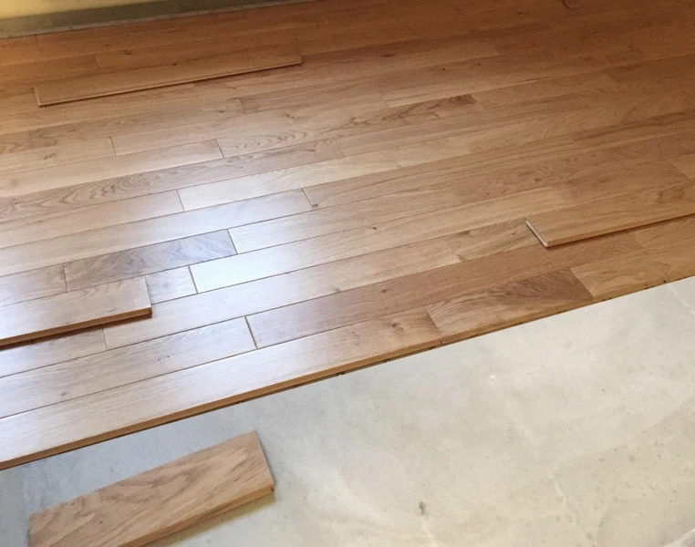 Intérieur résidentiel avec table ronde en bois sur pieds tournés placée au centre d'une pièce lumineuse aux fenêtres habillées de rideaux