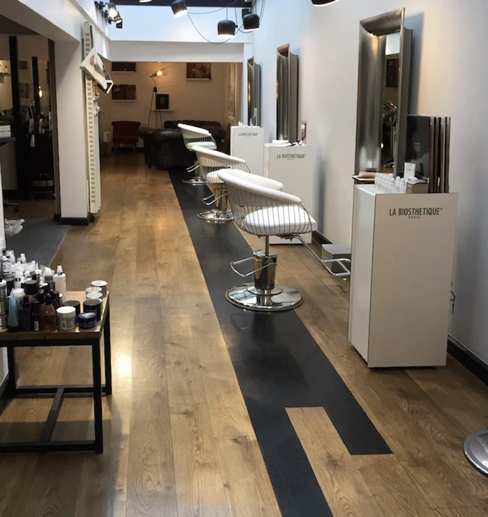 Salle d'exposition d'art contemporain avec sol en parquet verni très brillant créant des reflets parfaits