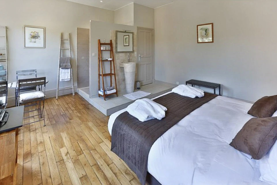 Vaste hall intérieur avec colonnes blanches et sol en parquet massif à motifs géométriques